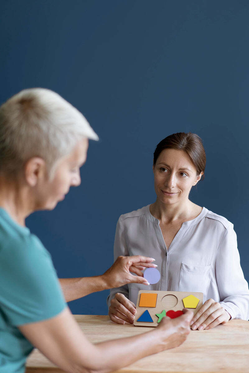Two women doing a shape-sorting exercise together at a table