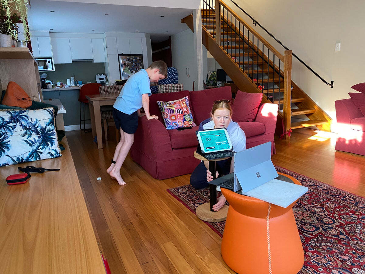 A mother and son looking at exercise software on a tablet and laptop