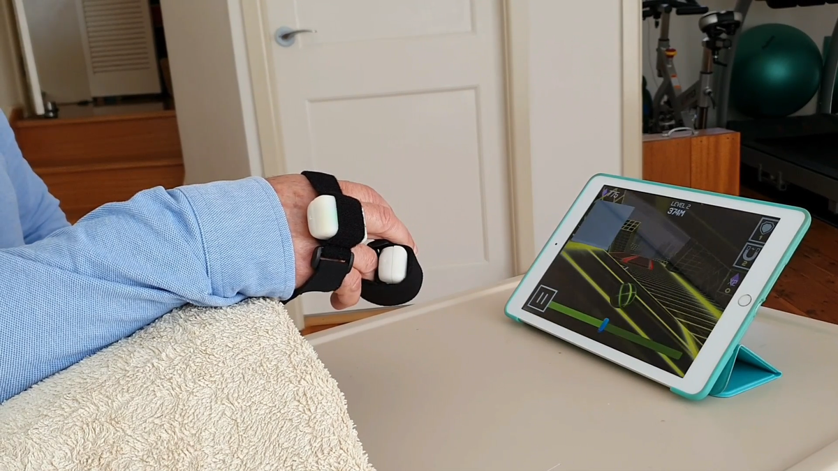 A hand wearing wireless sensors to control a tablet exercise game