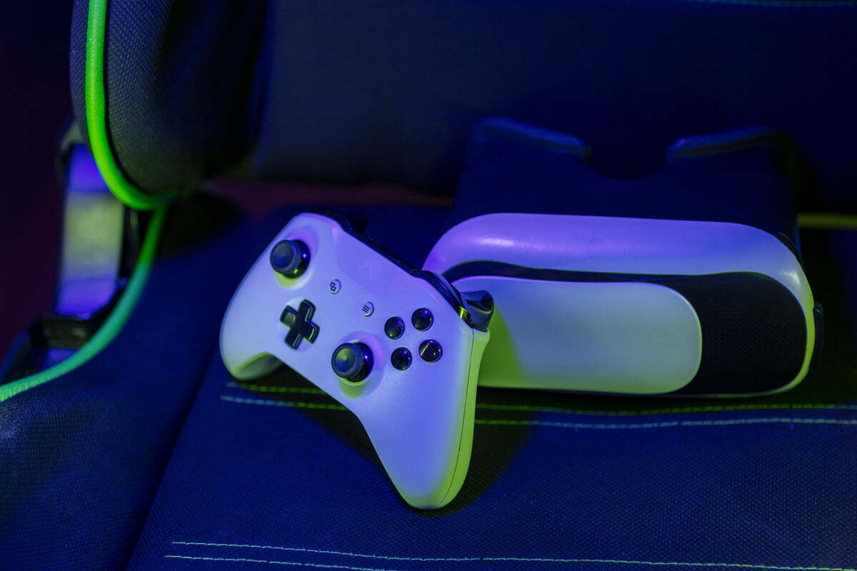 A game controller and headset resting on a gaming chair
