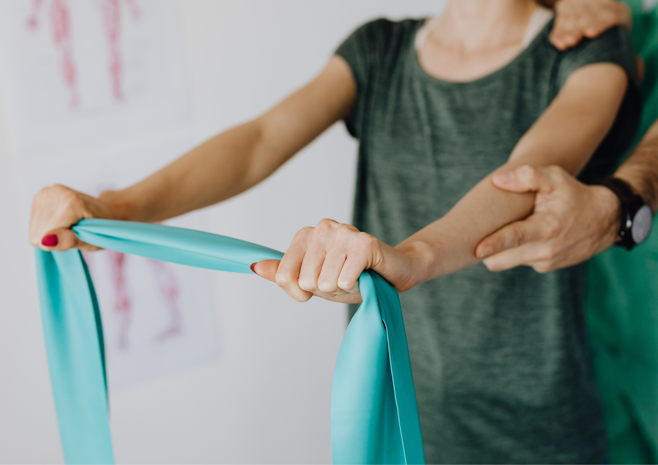 A therapist guiding a client's arm through a resistance-band exercise